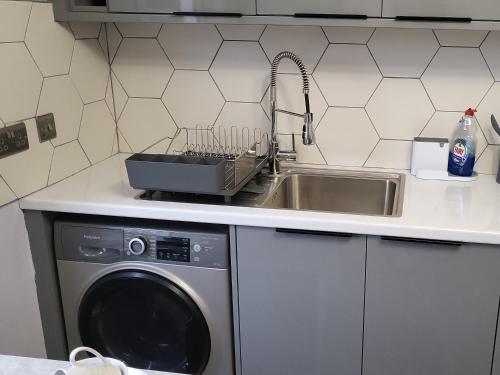 a kitchen with a sink and a washing machine at The Sankofa in London