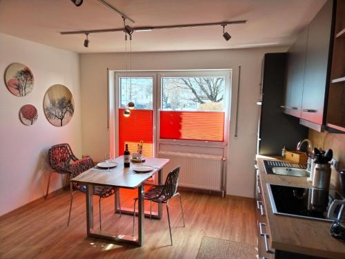 eine Küche mit einem Tisch und Stühlen sowie einem Fenster in der Unterkunft Ferienwohnung am Gänsbach in Grassau