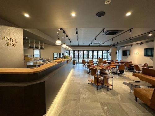 un ristorante con bar, tavoli e sedie di HOTEL ALGO a Kobe