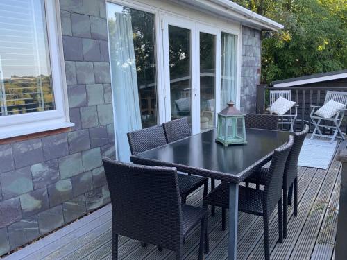 a black table and chairs on a screened porch with a table and chairs at CRIB GOCH HOLIDAY CABIN SNOWDONIA in Caernarfon