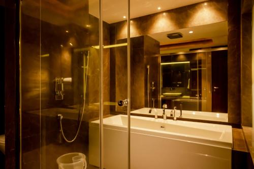 a bathroom with a glass shower and a sink at HOTEL PAHADI in Rourkela