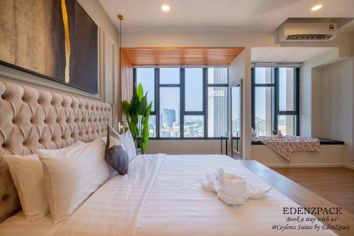 a bedroom with a large white bed with a large window at Ceylonz Suites by EdenZpace in Kuala Lumpur