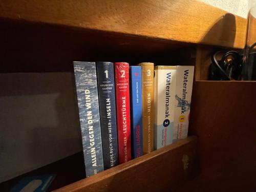 a row of books sitting on a book shelf at Süsses Motorboot - Bremen Überseestadt in Bremen