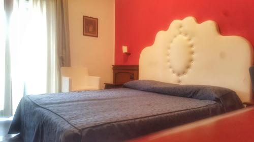 a bedroom with a bed and a red wall at La Bruca Resort in Scalea