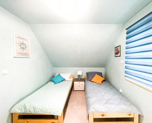 2 łóżka pojedyncze w niewielkim pokoju z oknem w obiekcie Zatoka Perska - Domek Włoch - Jezioro Tarnobrzeskie w Tarnobrzegu