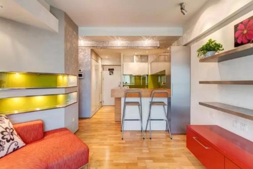 a living room with a couch and a kitchen at Beijing Yasmine Seasons Park Apartment Hotel in Beijing