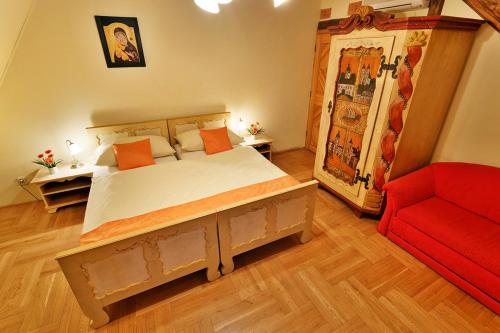 a bedroom with a bed and a red couch at Penzion U Kriveho psa in Frýdek-Místek