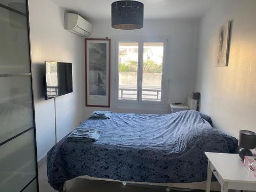 mała sypialnia z łóżkiem i oknem w obiekcie Appartement à 20 mètres de la plage avec balcon w Marsylii