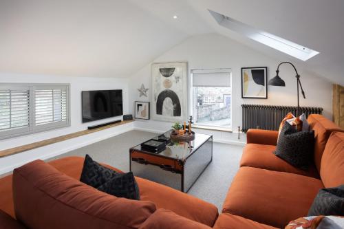 a living room with an orange couch and a coffee table at The Workshop in York
