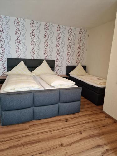two twin beds in a room with wood floors at Hotel Weinhaus Am Stiftstor in Treis-Karden