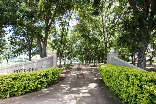 a path through a park with trees and a sign at Porterfield Guest House, Champagne Valley in Champagne Valley