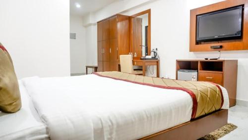 a hotel room with a bed and a tv at The Altruist Business Hotel Navi Mumbai-1 in Navi Mumbai