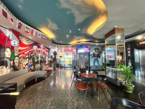 a room with a bar with chairs and tables at The Elopura Hotel in Sandakan