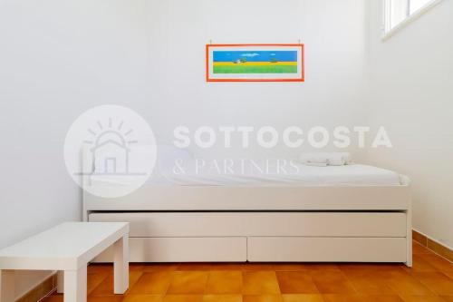 a white bedroom with a bed and a bench at Heavenly flat- Torre dell'Orso in Torre dell'Orso