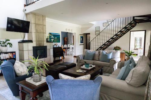 a living room with couches and a couch and a tv at Champagne Properties, Porterfield Estate in Champagne Valley