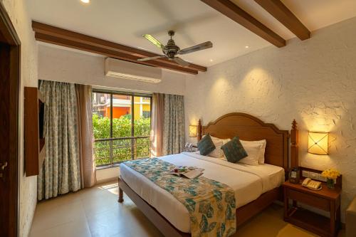 a bedroom with a bed and a large window at Adamo The Bellus in Calangute