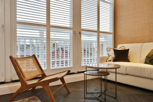 a living room with a couch and a table and windows at De Lindenhoeve Boutique Hotel in Sluis