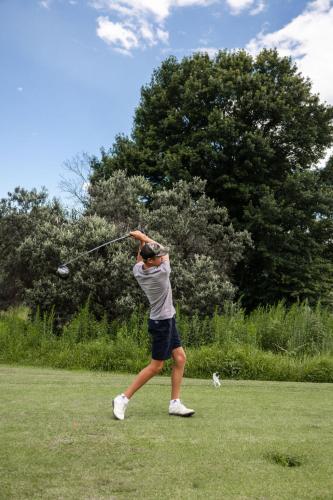 a woman hitting a golf ball with a club at Porterfield Guest House, Champagne Valley in Champagne Valley