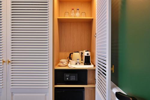 a kitchen with a coffee maker in a cupboard at De Lindenhoeve Boutique Hotel in Sluis