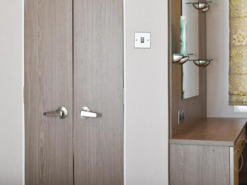 a wooden door in a bathroom with a sink at West Mersea Park in West Mersea