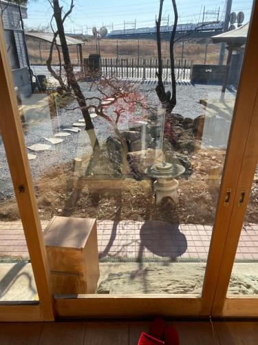 a sliding glass door with a view of a yard at 田舎庵 in Hanyu