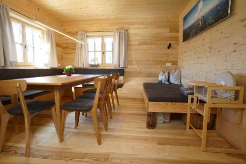 a dining room with a table and chairs at Hirschberghütte in Bizau
