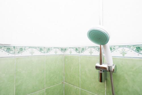 a shower with a shower head in a bathroom at RedDoorz Syariah near Exit Tol Krapyak Semarang in Kalibanteng-kidul