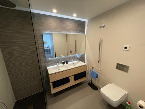 een badkamer met een wastafel, een toilet en een spiegel bij Ocean View Top Luxury New Built T1 -WPOV1 in Cabanas de Tavira