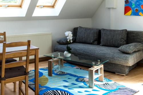 a living room with a couch and a glass table at Landhotel Cafe Prälank in Neustrelitz