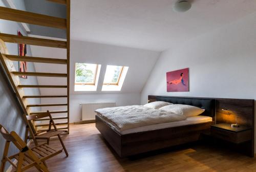 a bedroom with a bed and a chair in it at Landhotel Cafe Prälank in Neustrelitz