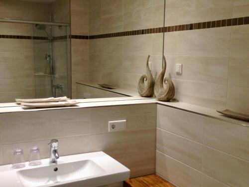 ein Bad mit einem Waschbecken und einem Spiegel in der Unterkunft Lindenpalais Wohnung 24 in Heiligendamm