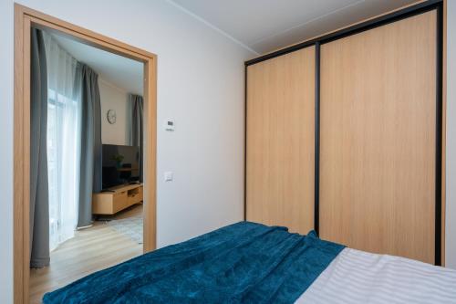 Un dormitorio con una cama y un gran armario de madera. en Aatrium Kinnisvara Riia str 20A apartment, 7-th floor, en Tartu