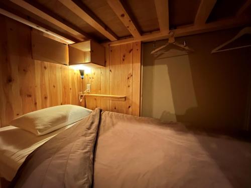 a bed in a room with a wooden wall at No Borders Hostel in Tokyo