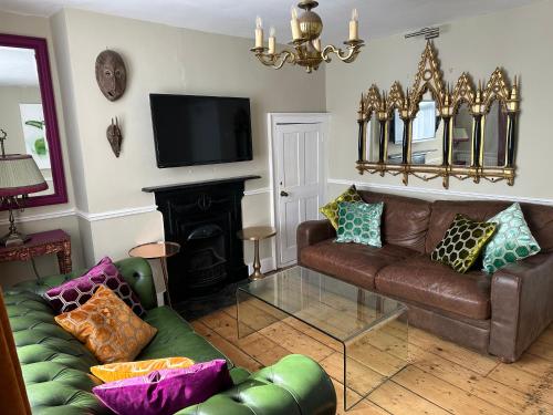 a living room with a leather couch and a fireplace at The Artist House in Brighton & Hove