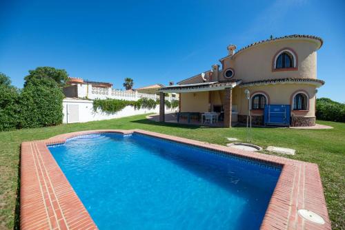 a house with a swimming pool in front of a house at LXR Villa frente al Mar 3HAB in Mijas