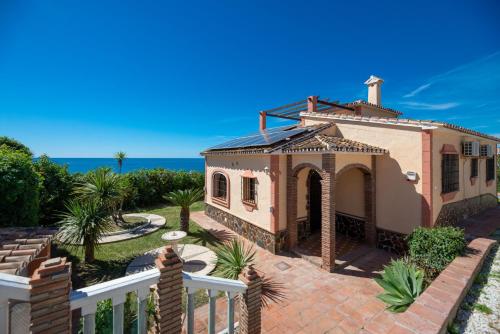 una casa con una cerca blanca junto al océano en LXR Villa frente al Mar 3HAB, en Mijas