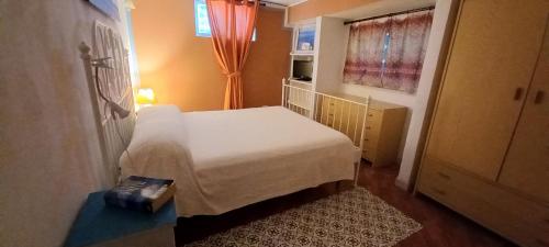 a small bedroom with a bed and a window at A Due Passi Dal Mare Con Piscina in Fontane Bianche