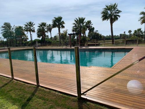 une grande piscine avec une terrasse en bois dans l'établissement LM APARTAMENTOS PLAYA GRANADA Dos Mares, à Motril