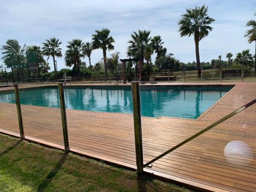 a large swimming pool with a wooden deck at PLAYA GRANADA Dos Mares in Motril