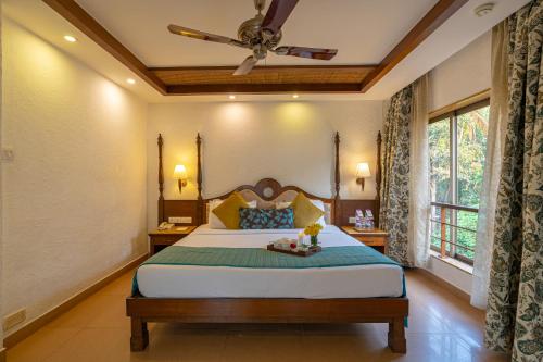 a bedroom with a bed and a ceiling fan at Adamo The Bellus Calangute in Calangute