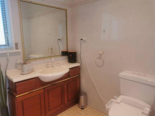 a bathroom with a sink and a mirror and a toilet at Lake View House entire house in Gosford