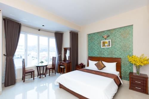 Queen Garden Hotel & Apartment في فنغ تاو: غرفة نوم بسرير وطاولة وكراسي