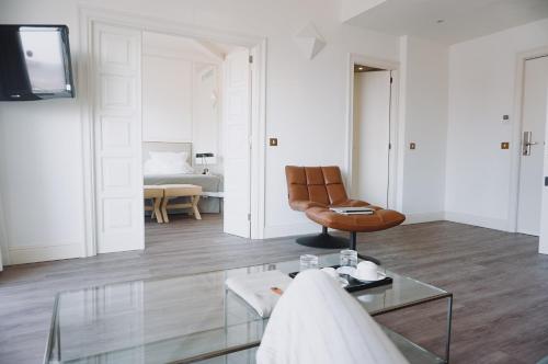 a living room with a leather chair and a table at Hoposa Daina- Adults Only in Port de Pollensa
