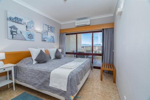 ein Schlafzimmer mit einem großen Bett und einem Fenster in der Unterkunft Praia Mar - Apartamento Viva Local in Portimão