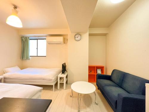 大阪市にあるREIWA HOUSEのソファとベッドとテーブルのある部屋