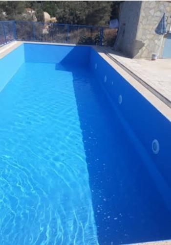 a large blue swimming pool with blue water at Modestus pansiyon otel in Usak