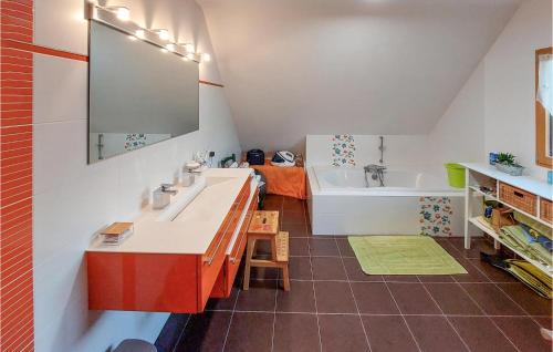 La salle de bains est pourvue de 2 lavabos et d'une baignoire. dans l'établissement Amazing Home In Montfort-sur-meu With Private Swimming Pool, Can Be Inside Or Outside, à Montfort-sur-Meu