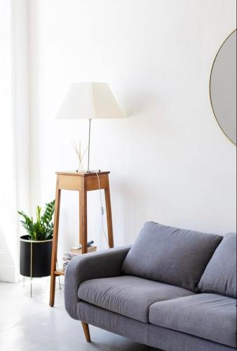 un salon avec un canapé et une lampe dans l'établissement Vue imprenable sur le port, charmant et clair!, à Vannes