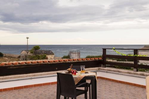a table and chairs on a balcony with a view of the ocean at Al Vecchio Frantoio al Mare in Monopoli