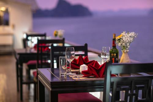 a table with glasses and wine bottles on it at La Regina Classic Cruise in Ha Long